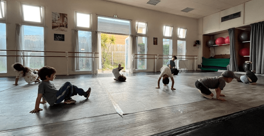 Photo d'enfants faisant des figures de Hip Hop au sol avec une description du cours d'éveil à la danse.